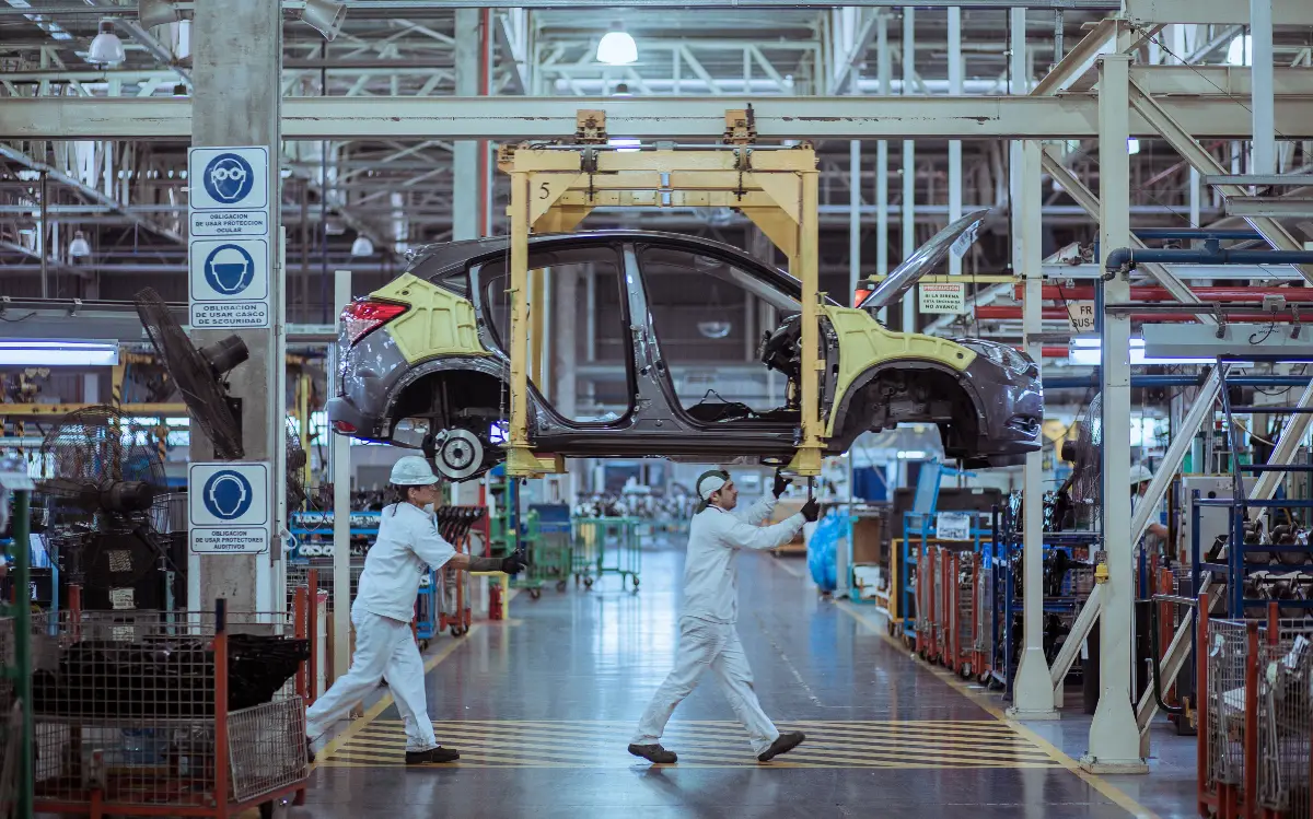 workers moving an electric car in factory