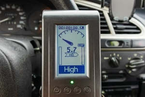 EMF meter showing a 5.7 mG magnetic field reading inside a car cabin